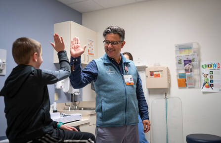 Dr. Amer Al-Nimr high fives with a patient