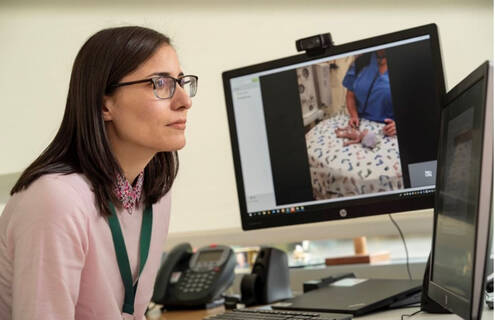 Michelle D. Tyler, MD, Dartmouth Health Children’s neonatologist, assists a local bedside provider in assessing an infant.