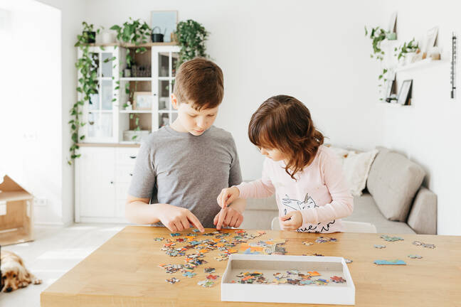Two kids making a puzzle together