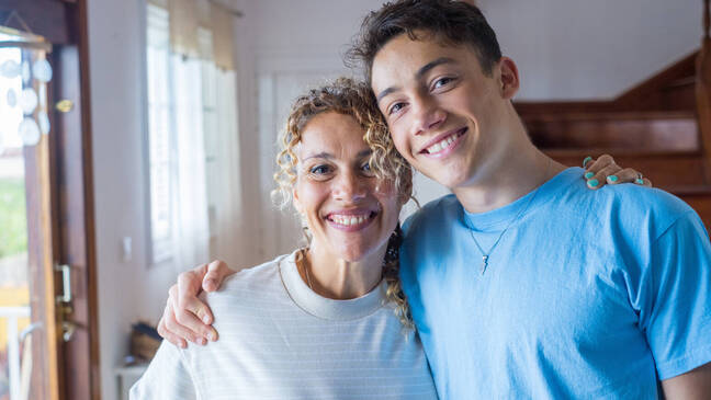 Mother and son side hugging and smiling posing for a photo
