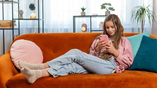 Girl sitting on couch holding phone